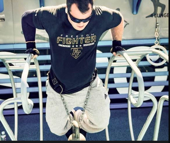 Athlete performing weighted dips in a gym